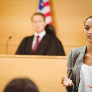 A woman in front of judges and the judge.