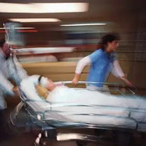 A patient is being carried in a hospital bed.