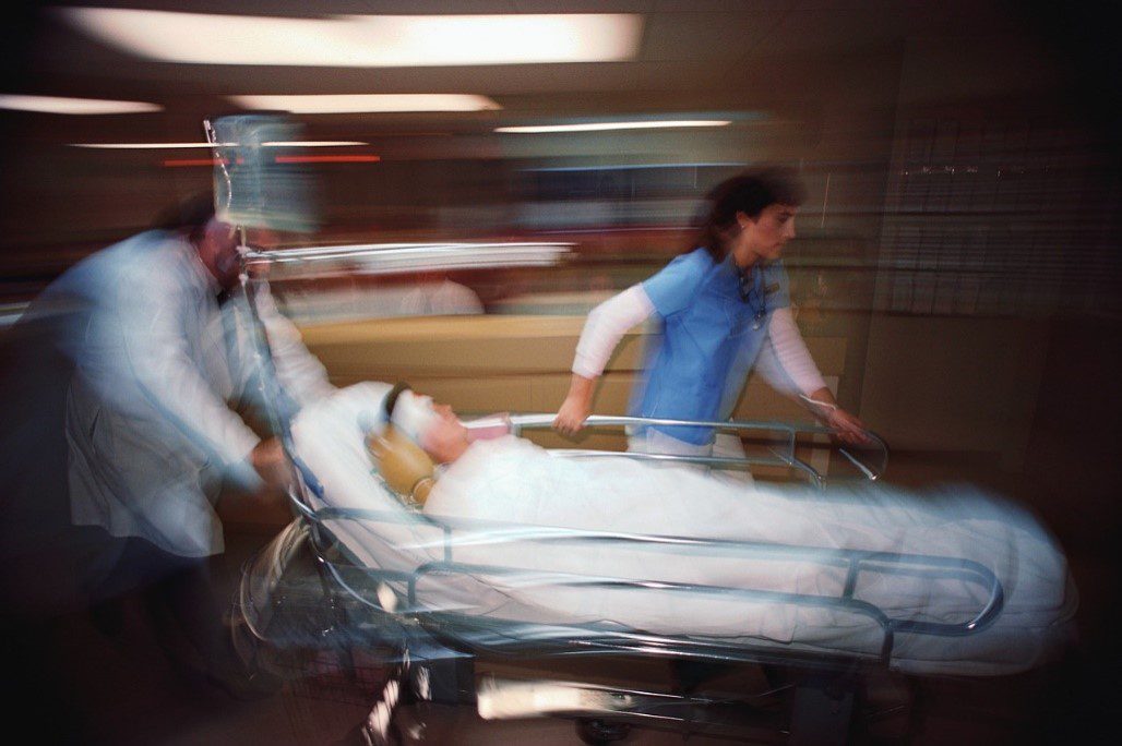 A patient is being carried in a hospital bed.