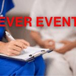 Close-up of nurse writing on medical chart during outpatient visit.